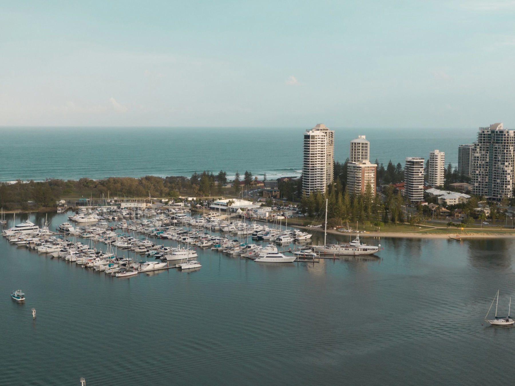 Yachts moored at a Gold Coast marina with the ocean beyond